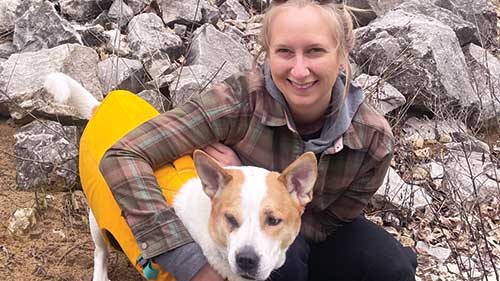Alumni smiling with dog