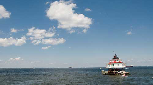 Large panoramic shot of the ocean with a lighthouse