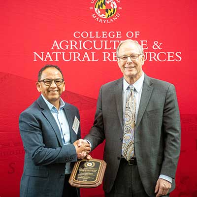 Faculty and staff award recipient smiling with the dean.