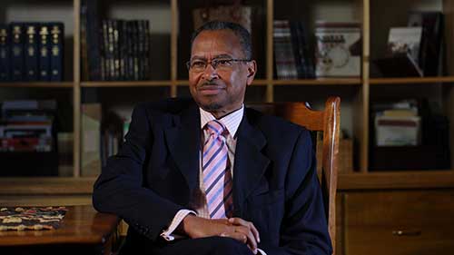 Jimmy Smith smiling in front of a bookcase.