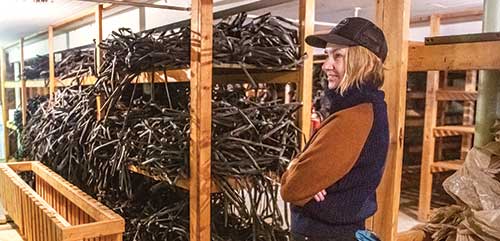 Krisztina Christmon standing in a barn next to farm plastic