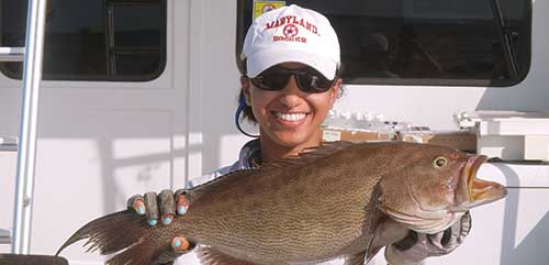 Samara Nehemiah holding up a fish on a boat