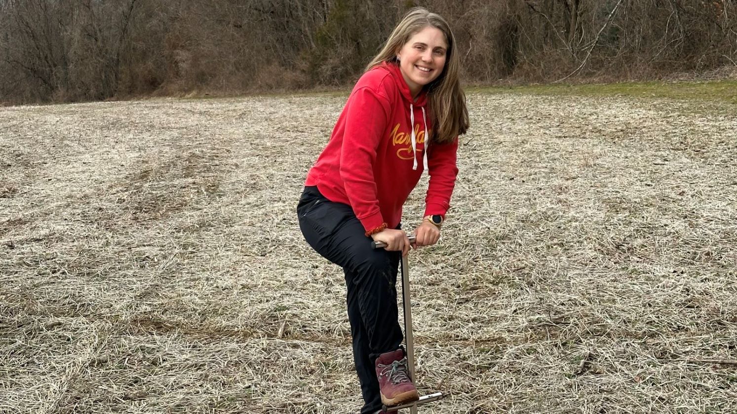 PhD student Emily in the field smiling