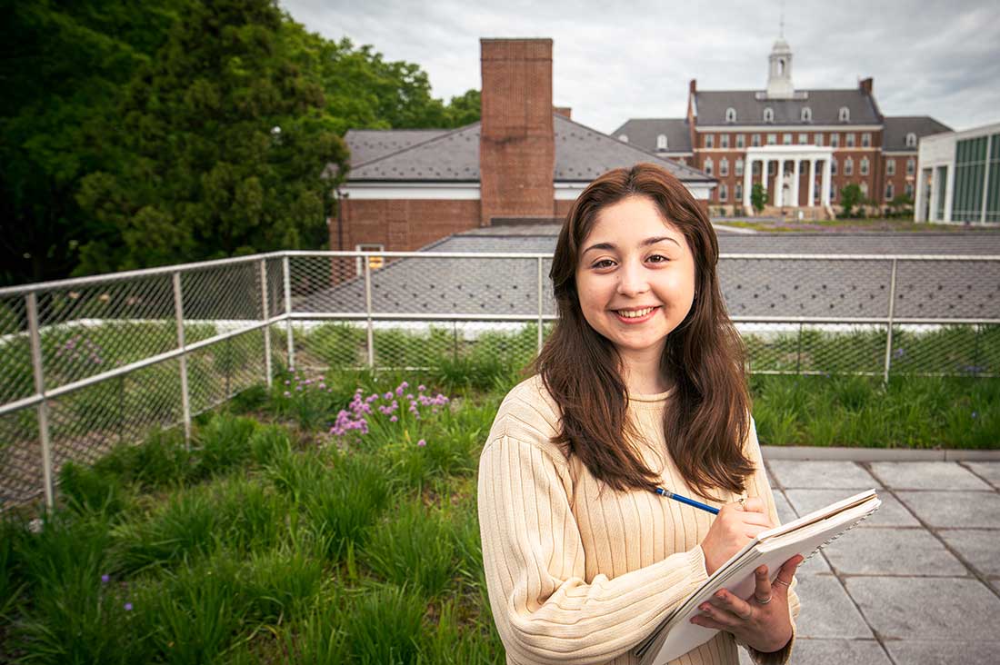 Landscape Architecture student on a green roof with a notebook