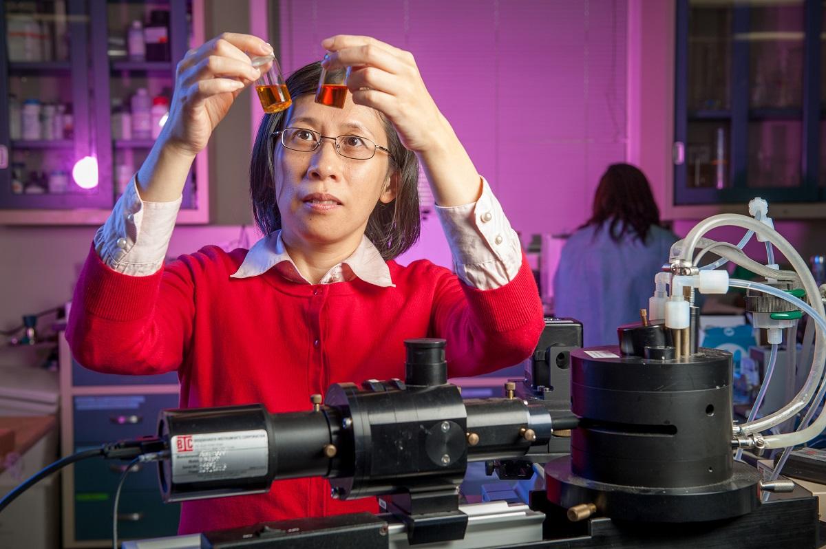 Female scientist in the lab looking at test tubes