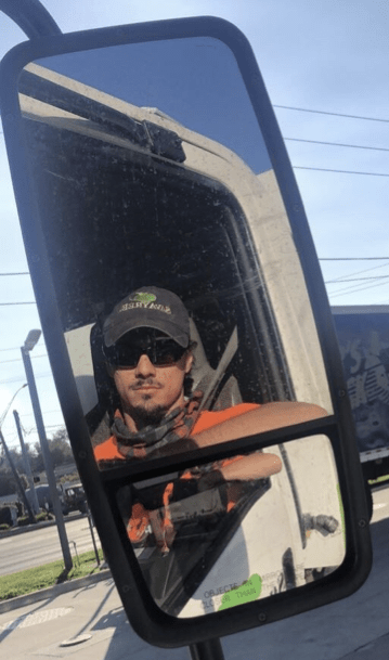 John looking in mirror of truck during his internship