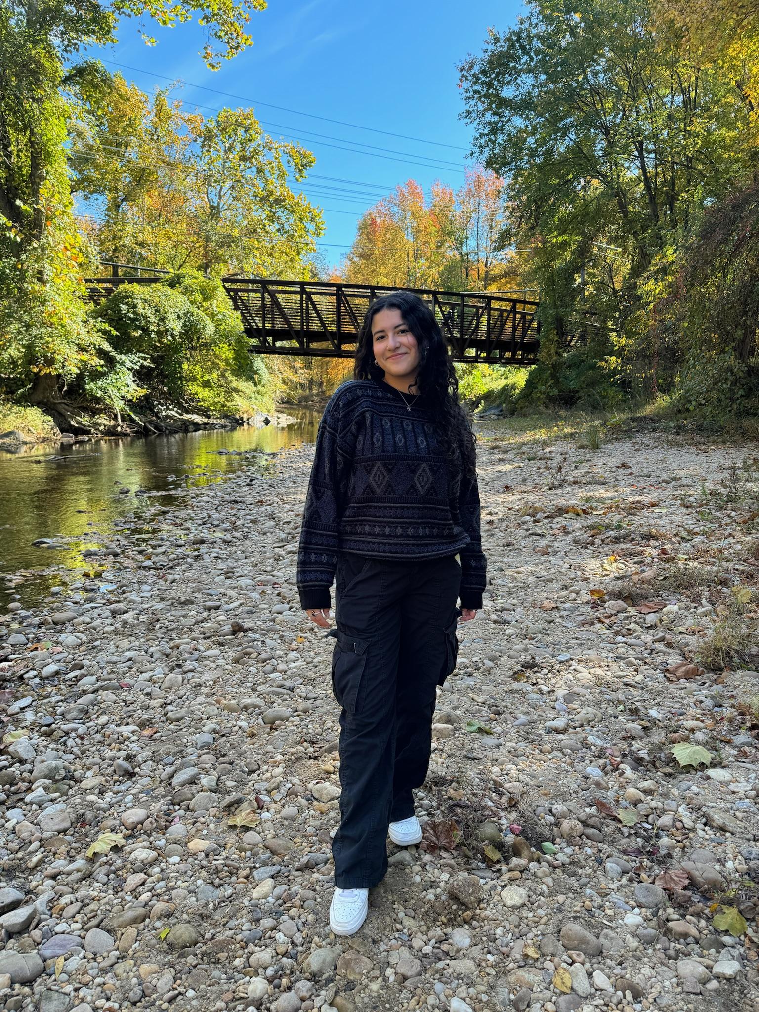 Student standing alongside a streambed.
