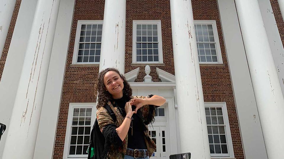 Peer mentor in front of Symons Hall