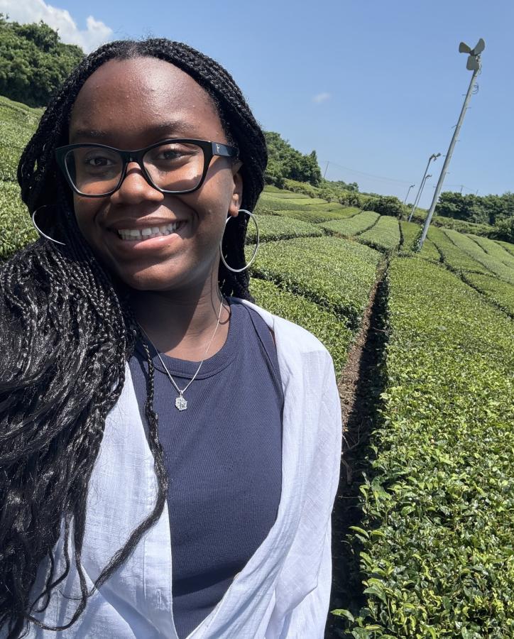 A student poses happily on an agricultural field.